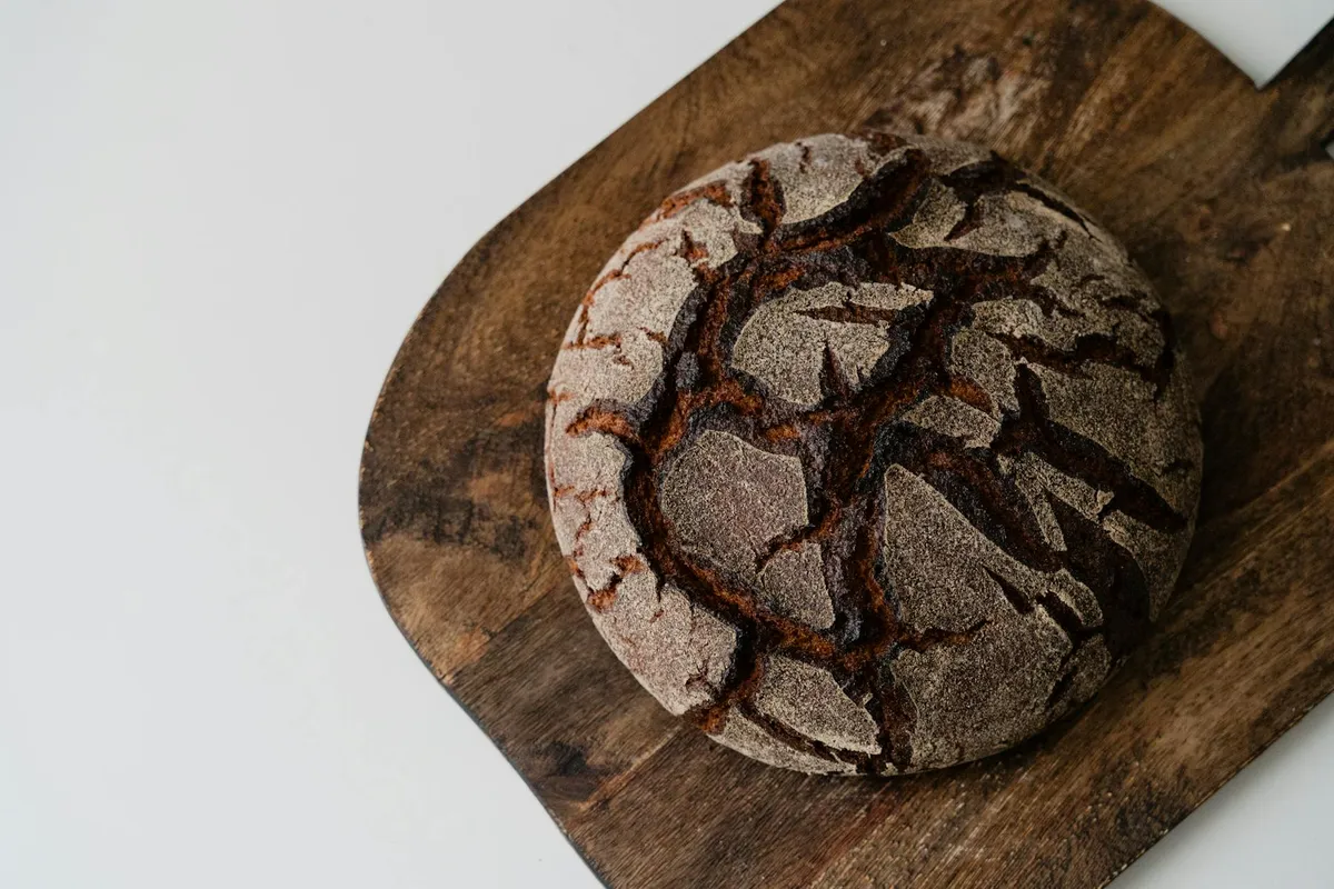 A crusty sourdough loaf on a wooden cutting board