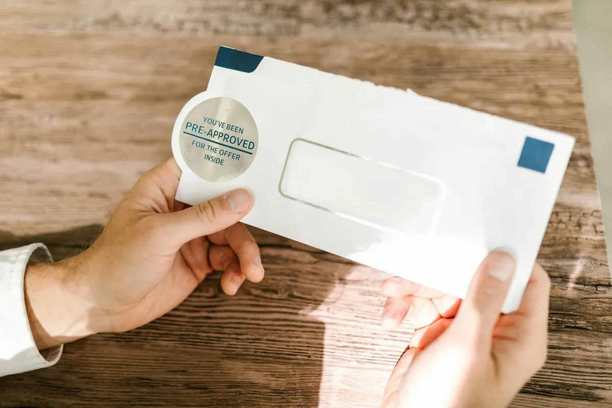 A stack of unopened mail on a small wooden table